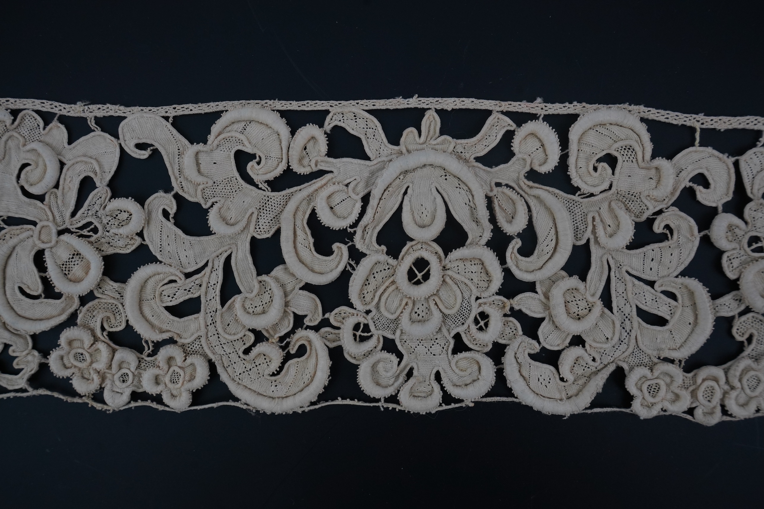 A length of 1660-1670 Italian Venetian Gros Point needle lace, this heavy needle lace was made with a wide cordonnet padded with wool, using close buttonhole stitch, to create large scrolling patterns in heavy relief, li